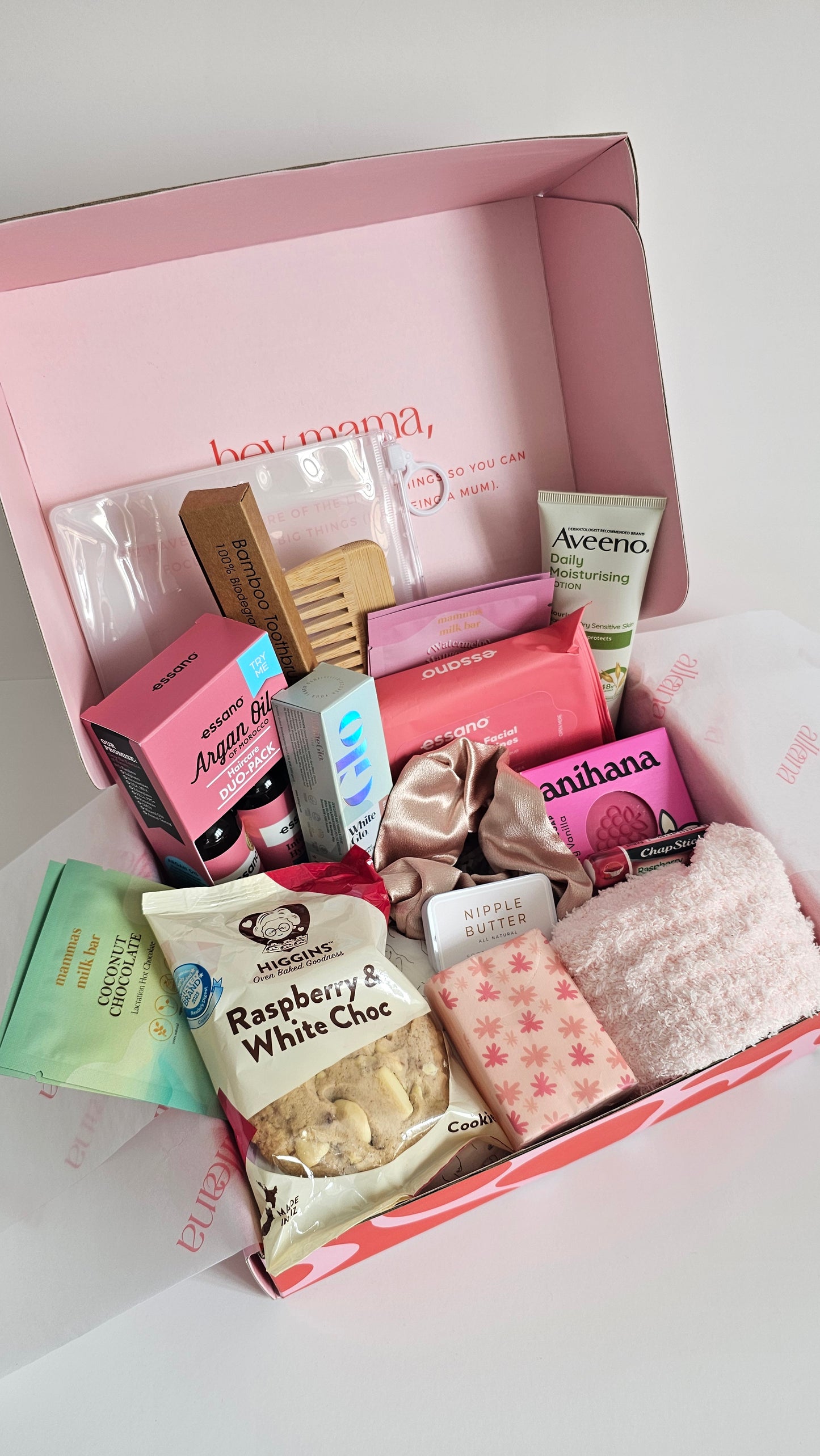 Pink box filled with various skincare and beauty products on a white background