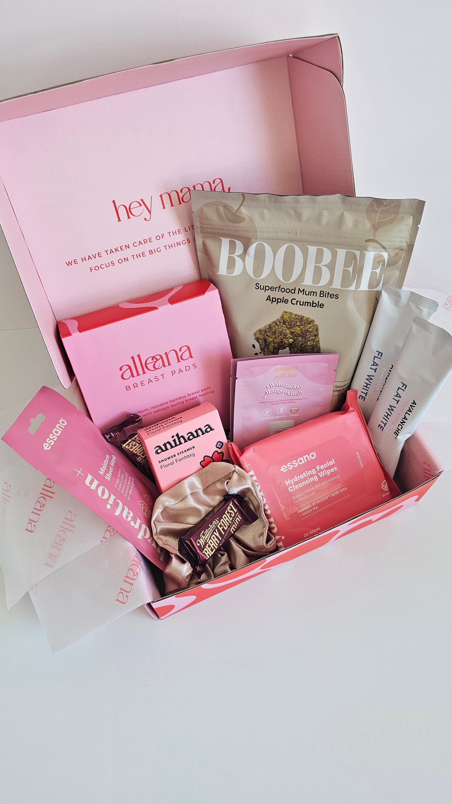 New mum and postpartum essentials gift box with pink products, lactation treats, nursing pads and self-care items