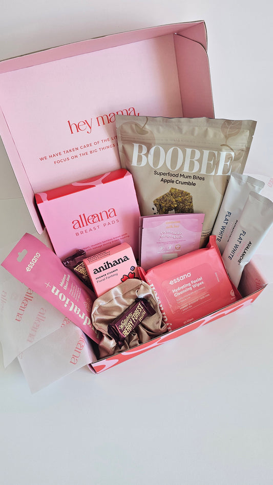 New mum and postpartum essentials gift box with pink products, lactation treats, nursing pads and self-care items